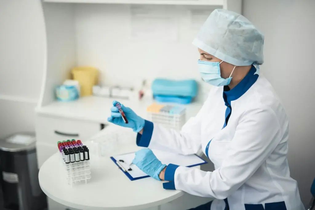 Scientifique en laboratoire manipulant un tube de prélèvement pour un projet pharmaceutique